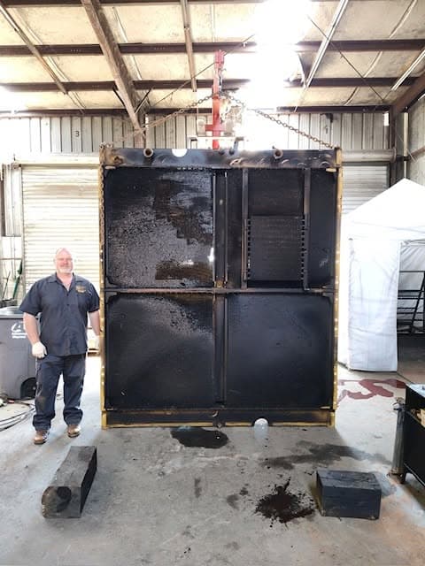 Port City Repair technician with a rebuilt industrial radiator